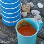 Roast tomato and pepper soup for a winter picnic, served in light blue plastic mugs and with a vintage striped blue and white flask.